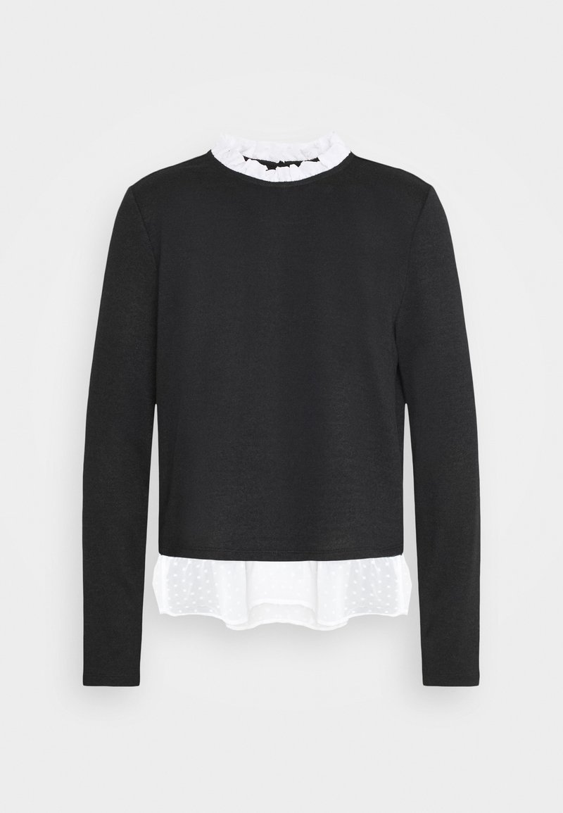 Haut noir à manches longues avec col montant à volants blanc et tissu blanc apparaissant sous l'ourlet, avec une texture subtile à pois.