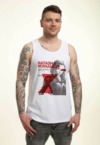 Hvid tanktop med et grafisk print af Natasha Romanoff (Black Widow) med røde accenter og tekst, imod en neutral baggrund.
