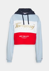 Skračená mikina s kapucňou v modrej, bielej a červenej farbe. Obsahuje zlaté logo "Tommy Jeans" a text "NEW YORK CITY". Námornícka kapucňa s šnúrkami. Mäkký bavlnený materiál.