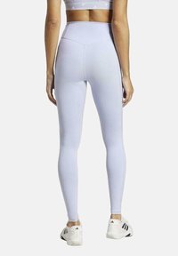Weiße, hoch taillierte Leggings mit glatter Textur, ausgestattet mit einer Gesäßtasche und minimalen Nähten für einen eleganten Look.