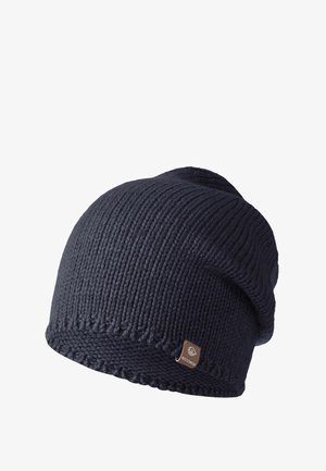 Bonnet en tricot de couleur bleu marine foncé avec un design à côtes texturé. Comprend une visière repliée et une petite étiquette métallique sur le côté.