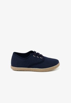 Zapatos azul marino con cordones, con una parte superior de tela texturizada y suela de yute trenzado. Presenta ojales metálicos redondos y un ajuste ceñido.