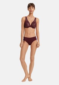 Set di lingerie bordeaux caratterizzato da un reggiseno a fantasia con spalline larghe e culotte a vita bassa abbinate, realizzato in un tessuto morbido e elasticizzato.