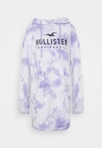 Mikina s kapucí v fialovém tie-dye vzoru, s přední kapsou a černým logem "Hollister California" na hrudi. Měkká bavlněná tkanina.