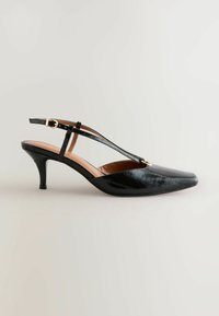 Sort slingback højhælet sko med spids tå, tekstureret mønster, justerbar rem og moderat hælhøjde. Glat indvendig foring.