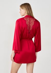 Accappatoio in raso rosso con maniche lunghe, caratterizzato da un design in pizzo sul retro. Include una cintura abbinata da annodare e una texture liscia.