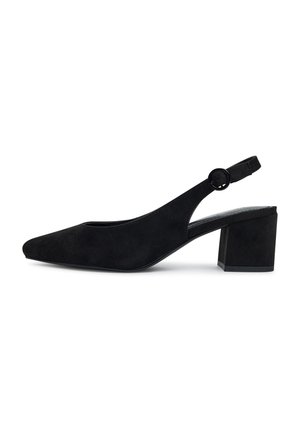 Zapato negro de ante tipo slingback con punta afilada y tacón medio cuadrado, que presenta una hebilla redonda en la correa ajustable.