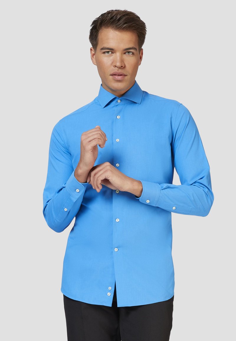 Camicia azzurra a maniche lunghe con colletto classico, vestibilità slim e bottoni bianchi. Il tessuto appare liscio e leggermente texture.