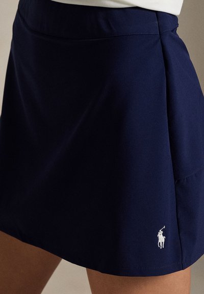 Granatowa spódnica wykonana z gładkiej tkaniny; posiada dopasowany pas i haftowane logo na brzegu. Krótki krój w kształcie litery A.