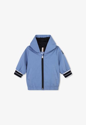 Lichtblauwe jas met een ritssluiting aan de voorkant, capuchon en elastische manchetten met marineblauwe en witte strepen. Het heeft twee voorzakken en een gestructureerde afwerking.