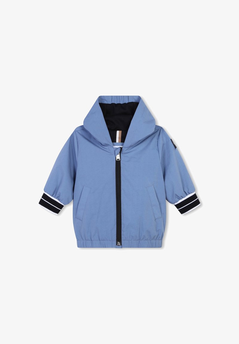 Veste bleu clair avec fermeture éclair à l'avant, capuche et poignets élastiques présentant des rayures bleu marine et blanches. Elle dispose de deux poches avant et d'une finition texturée.