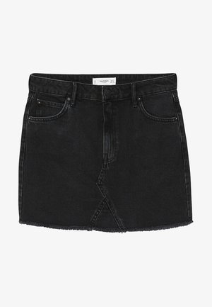 Jupe en denim noir à ourlet effiloché, associée à une chemise blanche boutonnée et un pull en maille beige drapé sur les épaules. Baskets beiges.