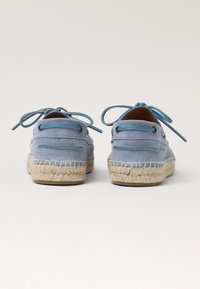 Bottines espadrilles en daim bleu avec des semelles en jute tressé et des lacets assortis, présentant une texture lisse et une silhouette arrondie.