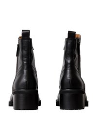 Botas de cuero negro hasta el tobillo con un tacón grueso, cierre de cremallera lateral y costuras texturizadas a lo largo de los lados. Acabado suave y diseño resistente.