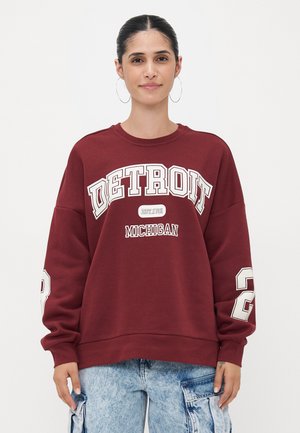 Kirsebærs Sweatshirt med "DETROIT" og "MICHIGAN" grafikk i hvitt, oversized passform, ribbestrikkede mansjetter, og et stort nummer "2" på ermet.