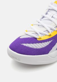 Adidași violet �și alb cu un upper din plasă texturată, accente galbene și vârf rotunjit. Prezintă un logo pe lateral și șireturi prin orificii.