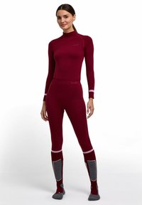 Bordowy termiczny zestaw bielizny bazowej składający się z długiego rękawa z wysokim kołnierzem oraz dopasowanych legginsów z szarymi akcentami i wypełnieniami.