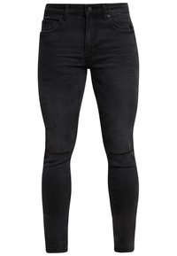 Černé džíny z denimu s úzkým střihem, pěti kapsami a opotřebovaným designem na koleně s roztřepenými okraji.