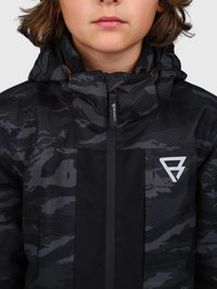 Kind trägt eine schwarz-grau gemusterte Jacke mit Kapuze, Reißverschluss vorne und einem weißen, dreieckigen Logo auf der Brust.