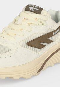 Κρεμ και καφέ αθλητικό παπούτσι Hi-Tec Shadow με λεπτομέρειες από δίχτυ και σουέντ, κρεμ κορδόνια και παχιά υφή στη σόλα.
