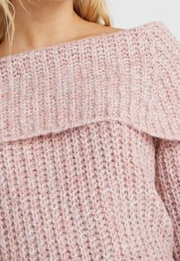 Maglione rosa chiaro scollo a spalla con una trama a maglia grossa. Presenta un colletto ripiegato e una vestibilità ampia, evidenziando un design morbido e accogliente.
