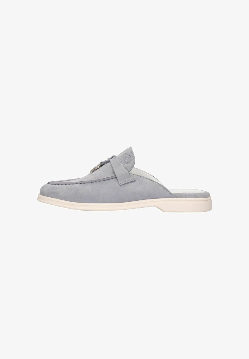 Scarpa slip-on in suede grigio con punta arrotondata, suola in gomma di colore chiaro a contrasto e dettaglio decorativo a fiocco sulla parte superiore.