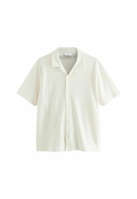 Camisa de manga corta en color crema con un patrón de diamantes texturado y un cuello tipo polo; cuenta con un cierre de botones en la parte delantera.