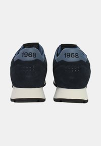 Scarpe sportive color blu navy in materiale scamosciato, con tallone di un blu chiaro a contrasto e dettagli neri. Il numero "1968" è ricamato sul tallone.