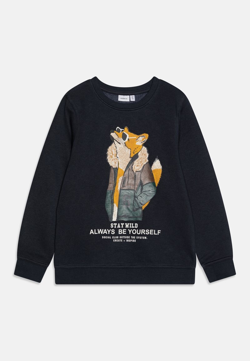 Sweatshirt bleu foncé avec un graphique de renard portant des lunettes de soleil et un parka. Le texte en dessous dit : "RESTEZ SAUVAGE, SOYEZ TOUJOURS VOUS-MÊME."