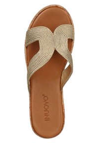Zlatý tkaný pásek na sandál s hladkou hnědou vnitřní podrážkou a texturovanou spodní částí. Obsahuje design křížového propletení pro bezpečné umístění nohy.
