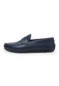 Mocasini din piele marine cu o textură împletită în partea din față, talpă din cauciuc plată și un design cu guler jos pentru o accesibilitate ușoară.