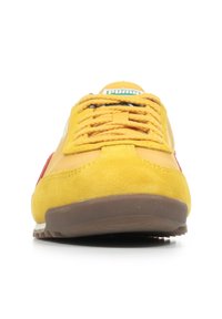 Sneaker in suede giallo con accenti rossi, punta rotonda e suola in gomma testurizzata. Presenta lacci gialli e un logo del marchio prominente sulla linguetta.