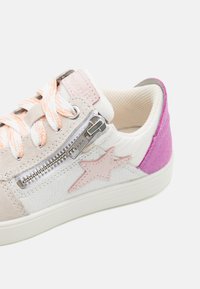 Kergelt beežist seemisest ja valgest nahast pealsest koosnevad sneakerid, roosa tähte ääristav, hõbedane külgvetti ja tekstuuriga roosa kann. Oranžid ja valged laced.