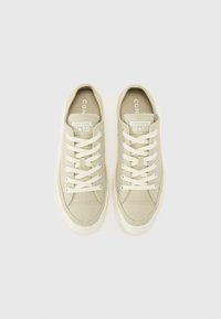 Svetlozelené plátené tenisky s okrúhlym špičkou, bielou gumovou podrážkou a kovovými očkami. Obsahujú tkaničky a branding "Converse All Star" na jazyku.
