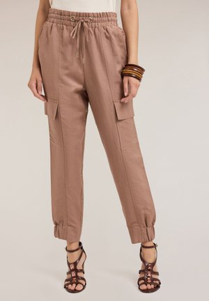 Pantalons cargo marron clair avec un cordon de serrage à la taille, des poignets fuselés et des poches latérales. Fabriqués dans un tissu doux au toucher lisse.