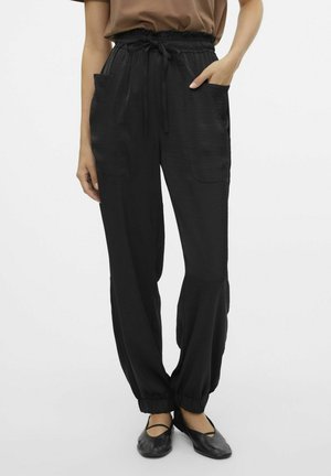 Pantaloni neri leggeri con vita elastica, cordoncino e orli alle caviglie. Presentano due tasche frontali. Tessuto liscio.