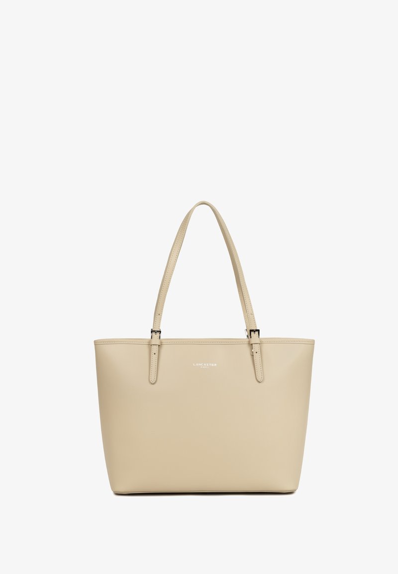 Sac fourre-tout en cuir beige avec deux bandoulières et un logo discret "Lancaster Paris" au centre à l'avant.