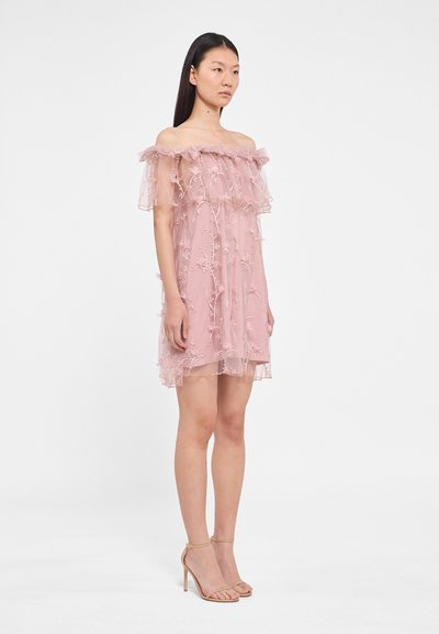 Roze off-shoulder jurk met gelaagd doorschijnend stof, bloemenborduursel en gerimpelde accenten. Gecombineerd met naakte, bandjes hoge hakken.