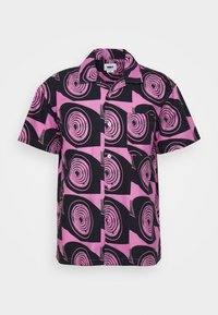 Lyhythihainen paita mustassa ja vaaleanpunaisessa, jossa on pyöreitä kuvioita ja kauluspääntie. Valmistettu kevyestä kankaasta, jossa on rento istuvuus.