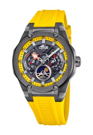 Lotus ura s kroglasto sivim ohišjem, črnim številčnikom z rumenimi in rdečimi akcenti ter rumenim silikonskim trakom. Vključena je funkcija dan-in-čas.