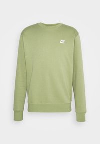 Grön bomullströja med rund halsringning och långa ärmar, med en liten vit Nike-logotyp på bröstet. Slät textur och avslappnad design.