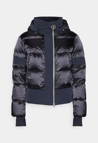 Navy pufferjack met een glanzende afwerking, cropped ontwerp, capuchon en ritssluiting. Voorzien van elastische manchetten en contrasterende textuurpanelen.