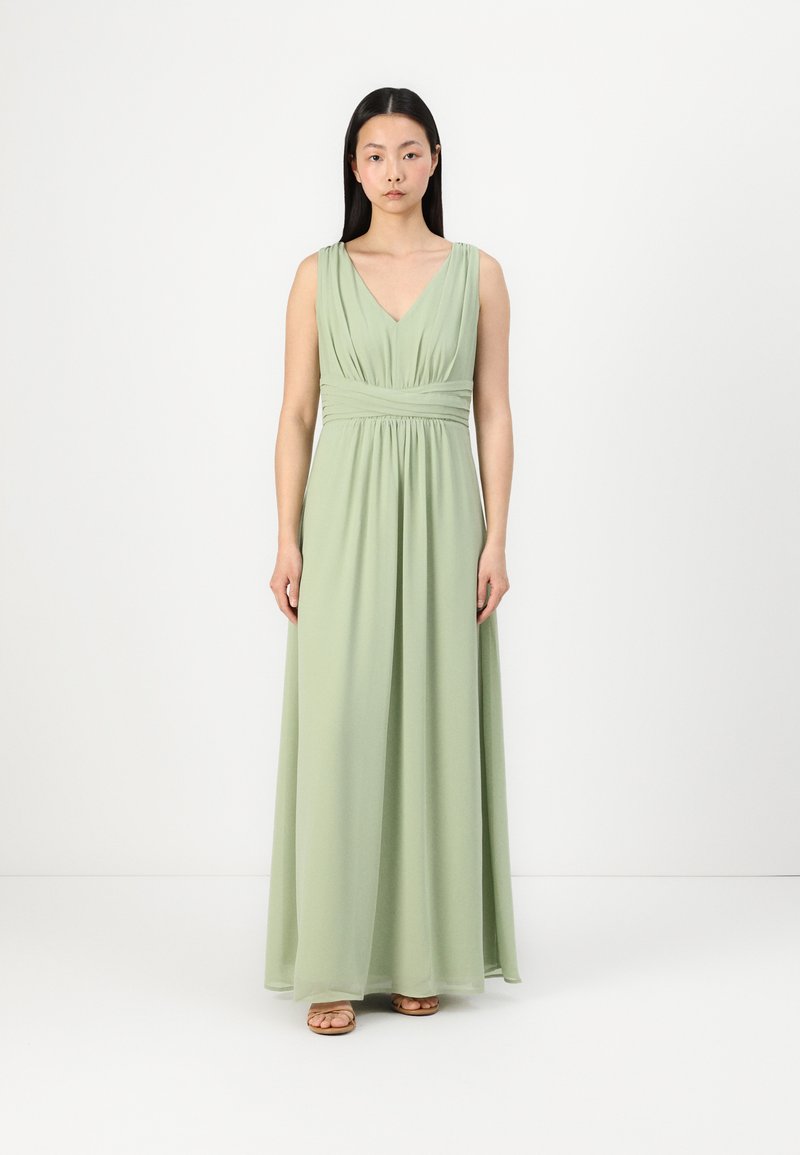 Hosszú, ujjatlan, V-nyakú ruha puha világoszöld szövetből, összeválogatott derék részlettel, áramló szoknyával és minimalista kialakítással.