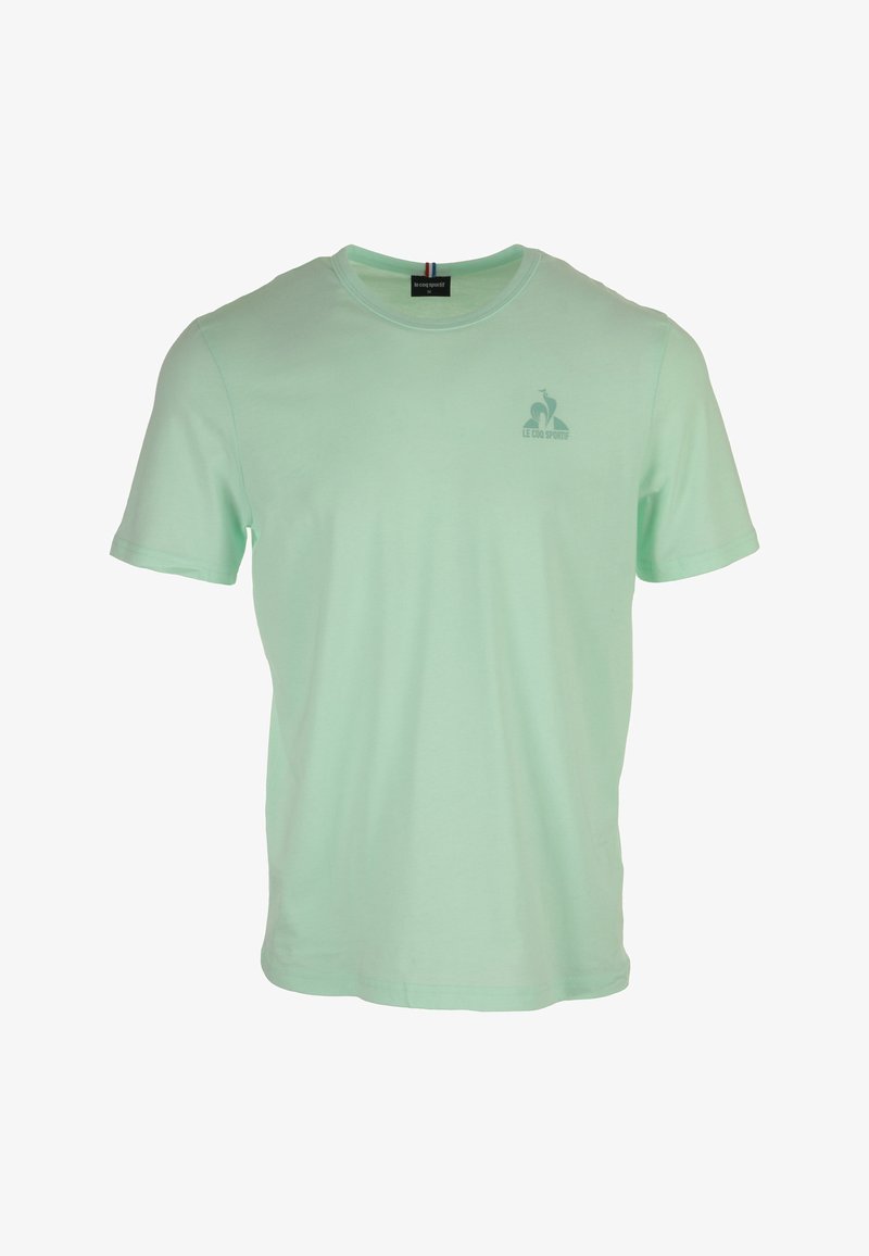 T-shirt in cotone verde menta con maniche corte, scollatura a girocollo e una piccola stampa del logo sul petto. Texture liscia, design casual.