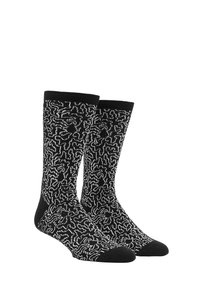 Chaussettes noires avec un motif de labyrinthe abstrait blanc, dotées d'un renfort à la pointe et au talon. Fabriquées dans un tissu doux et texturé pour plus de confort.