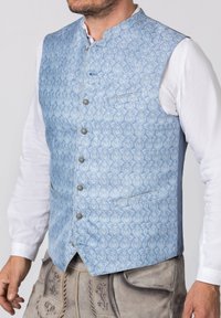 Hellblaues Weste mit intricaten weißen Blumenmustern, ausgestattet mit einem Mandarin-Kragen, Frontknöpfen und zwei Seitentaschen, getragen über einem weißen Hemd.