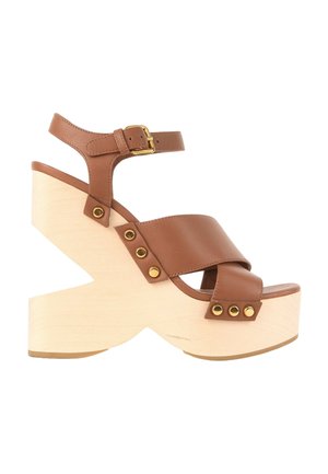 Sandale à plateforme en cuir marron avec semelle épaisse en bois clair, bride de cheville avec boucle dorée et détails en rivets dorés.