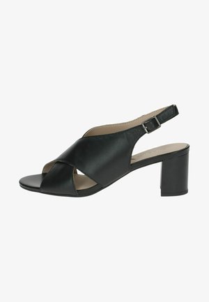 Sandale à talon slingback en cuir noir avec un design croisé, bout ouvert et un talon bloc moyen, dotée d'une bride réglable avec boucle.