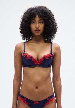 Granatowy koronkowy biustonosz z czerwonymi kwiatowymi akcentami, z fiszbinami, regulowanymi ramiączkami i małą kokardką na środku. Dopasowane bikini.