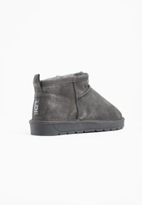 Botas de tobillo de ante gris con un suave forro de piel de fur, puntera redondeada y suela de goma texturizada. Presenta una costura cosida y una etiqueta de marca en el tacón.